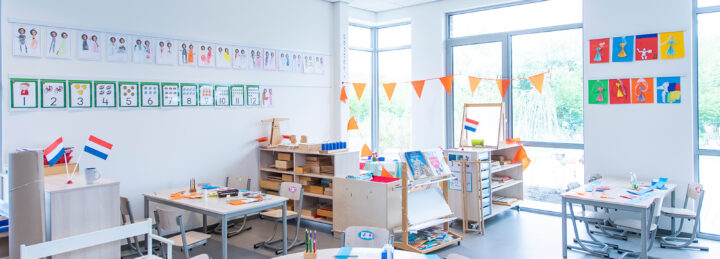 DE Info Rail an der Wand im Klassenzimmer, gefüllt mit Zeichnungen